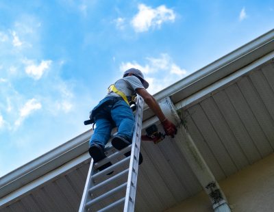 Ken's Gutters employee inspecting a downspout and gutter system.